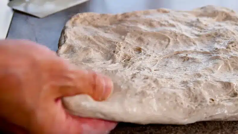 パン生地にパンチを入れる手元の様子