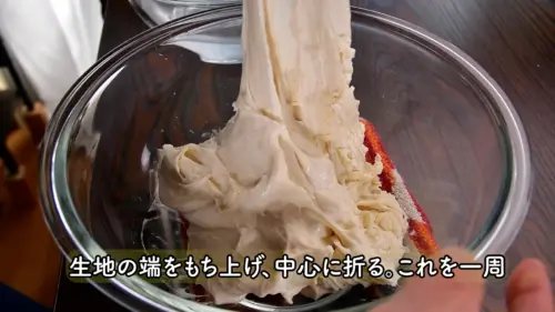 バゲット生地にコシを出すためのパンチ（折りたたみ）作業の様子